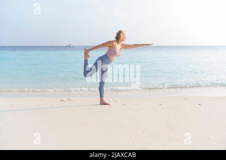 Une femme sportive fait du sport sur la plage. Banque D'Images