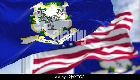 Deux drapeaux de l'État du Connecticut agitant avec le drapeau national des États-Unis d'Amérique. En arrière-plan, il y a un ciel clair. Banque D'Images