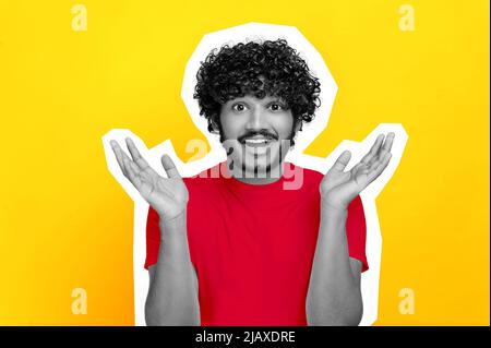 Surprise stupéfait homme maure indien ou arabe noir et blanc, en t-shirt rouge, regardant la caméra en incrédulité, en écartant ses bras sur les côtés, haussant, se tenir sur un arrière-plan orange isolé. Découpe Banque D'Images
