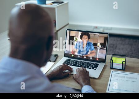 De jeunes hommes d'affaires afro-américains parlent lors d'une vidéoconférence sur ordinateur portable au bureau Banque D'Images