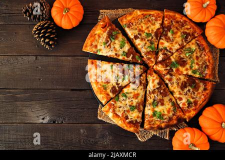 Pizza d'automne avec sauce potiron, gouda et oignons caramélisés. Vue ci-dessus sur un fond en bois sombre. Copier l'espace. Banque D'Images