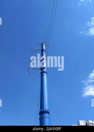 Lignes électriques haute tension d'un nouvel échantillon de couleur bleue contre un ciel bleu par temps ensoleillé Banque D'Images