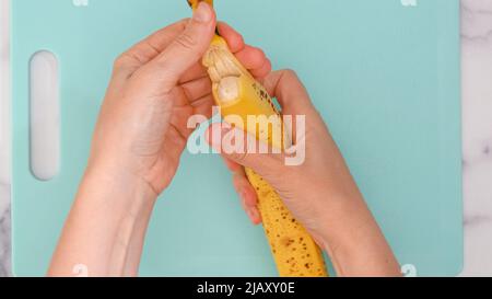 Femme peeling les mains de banane mûre fraîche, vue rapprochée d'en haut Banque D'Images