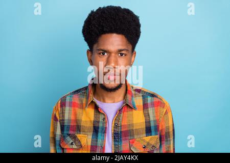 Photo du bon jeune gars brunet porter une chemise jaune isolée sur fond bleu Banque D'Images