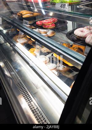 gâteaux et beignets en vente dans un comptoir de boulangerie réfrigéré Banque D'Images