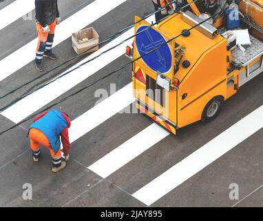 Marquage de ligne grande machine robotique ai, peinture d'un marquage zébré sur un passage de côté avec un spray thermoplastique sur l'asphalte Banque D'Images