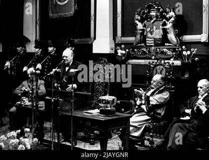 M. Winston Churchill étant applaudi dans la salle du Conseil de Bristol après avoir obtenu la liberté de la ville. Les 'personnes de distinction et toute personne qui a rendu un service éminent à l'arrondissement' peuvent être élus au rôle des hommes honoraires des grandes villes de Grande-Bretagne. 12 décembre 1955. Banque D'Images