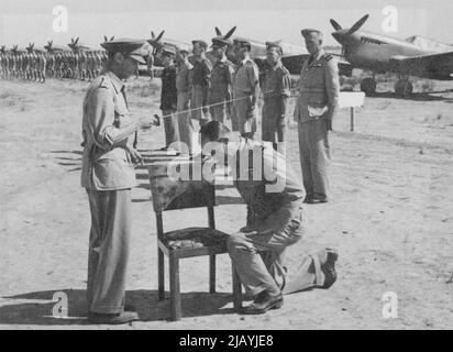 King visite Victor Desert Air pour E. accolade de chevalier conféré à l'adjoint A.O.C.-in-C -- le roi voit accorder l'accolade de chevalier au maréchal de l'air Sir Francis Linnell. De retour de Malte à l'Afrique du Nord, le roi a visité l'armée de 8th à Tripoli et la bataille H.Q. du général Montgomery. Il a également rendu visite à des hommes des forces aériennes du désert qui avaient contribué de manière si importante à la victoire de tota1 en Afrique. Il a décerné l'accolade de chevalier au maréchal de l'air Sir Francis Linnell, adjoint A.0.G.-in-C. R.A. F. Moyen-Orient. C'est la première fois dans l'histoire qu'une telle investiture Banque D'Images