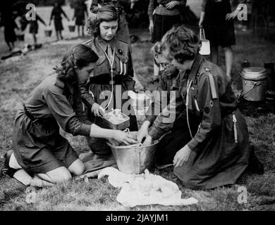 La princesse Elizabeth a passé sa première journée comme conseillère d'État au camp -- la princesse Margaret Rose aide à préparer un repas au camp. Les Princesses Elizabeth et Margaret Rose ont passé une journée dans le camp avec des filles guides aujourd'hui, c'était le premier jour comme conseiller d'État pour la princesse Elizabeth en l'absence de son père, le Roi, sur sa visite aux troupes en Italie. Les Princesses ont pris leur tour pour aider à cuisiner les repas et à laver les plats. 24 juillet 1944. Banque D'Images