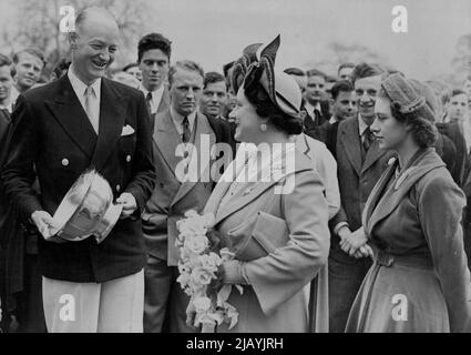 Gagné par Cambridge Boat Race Crew aux États-Unis H.R.N. Ricketts, l'entraîneur de l'équipage de la course de bateaux de l'université de Cambridge montrant à la Reine et à la princesse Margaret la réplique argentée du bol Paul Revere présentée à l'équipage de Cambridge pour commémorer leur victoire aux États-Unis sur Harvard. La photo a été prise lors de la visite royale à Cambridge aujourd'hui. La Reine porte un chapeau à bord retourné et orné d'un noeud en ruban. La princesse a un petit chapeau près ajusté et porte un trou de bouton de maïs. 27 avril 1951. (Photo de Paul Popper Ltd.). Banque D'Images