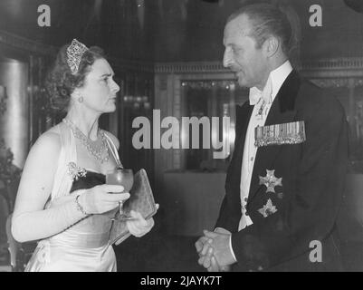 La duchesse participe au Snow ball -- la duchesse de Gloucester discute avec Sir Frederick Browning. La duchesse de Gloucester assiste à la boule de neige à l'aide de l'United Appeal for the Blind et de la British Empire Society for the Blind, qui a eu lieu à l'hôtel Dorchester, Londres, la nuit dernière. 16 décembre 1954. (Photo par image standard du soir) Banque D'Images