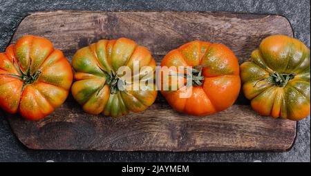 Un groupe de grosses tomates Costoluto sur fond de bois Banque D'Images