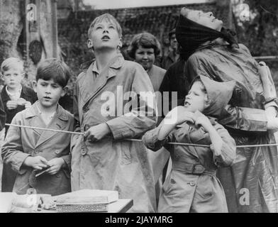 La duchesse britannique de Gloucester, son fils, les Princes Richard et la fille de la reine Elizabeth, la princesse Anne, regardent pour voir où le ballon qu'ils viennent de libérer est en pleine ascension, mais le prince Charles, frère de la princesse Anne, s'intéresse plus à la façon dont le ballon est rempli de gaz. La photo a été prise samedi à un fète presbytère à Barnwell, en Angleterre, ici les deux enfants royaux ont été des visiteurs étonnés. 07 août 1950. Banque D'Images