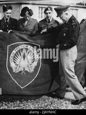 New Shape Flag est hissé - tenant le drapeau du général Eisenhower aujourd'hui, 5 octobre, sont (de gauche à droite) le chef de l'aviateur de la Force aérienne royale John Frances de Bratntree, Essex, Angleterre; le sergent d'état-major de l'armée néerlandaise Hennie Swaagman d'Assen, Hollande; Et le sergent Lawrence C. Oakley de l'Armée canadienne de 24, rue Brunsck, Armdale, Halifax, Canada. Un nouveau drapeau, en partie conçu par le général Dwight D. Eisenhower, commandant suprême des puissances alliées en Europe, a été hissé au-dessus du quartier général de SHAPE près de Paris aujourd'hui, en octobre 5. C'est une bannière verte portant les mots en or 'Vigilia Preplum Libertatis' Banque D'Images