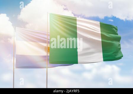 Ciel bleu ensoleillé et drapeaux du nigeria et de l'argentine Banque D'Images