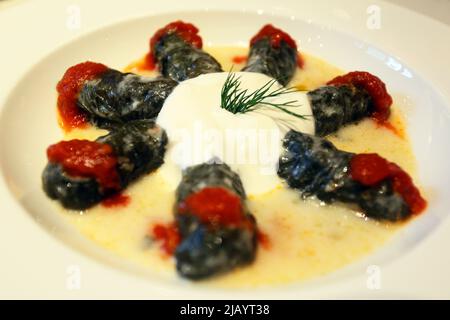 Verger farci avec sauce tomate et yaourt sur l'assiette à dîner. Banque D'Images