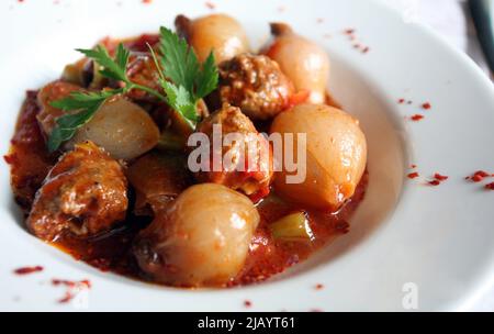 Émincez les boulettes de viande et les oignons sur l'assiette à dîner. Banque D'Images