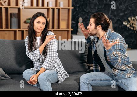 Clarification des relations entre conjoints. L'homme en colère hurle devant une femme, se sent en colère, se querellant au sujet du désaccord, la femme qui fait l'expérience d'abus psychologiques de son mari, a besoin de protection Banque D'Images