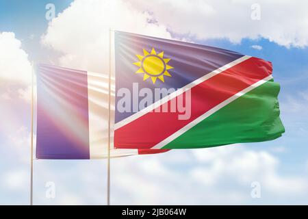 Ciel bleu ensoleillé et drapeaux de la namibie et de la france Banque D'Images