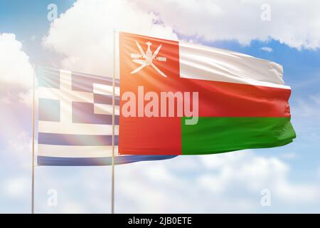 Ciel bleu ensoleillé et drapeaux d'oman et de grèce Banque D'Images