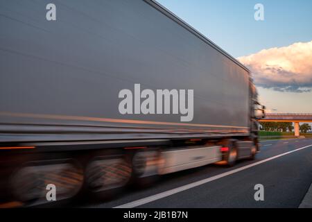 Camion sur l'autoroute pendant le coucher de soleil spectaculaire, flou de mouvement intentionnel Banque D'Images