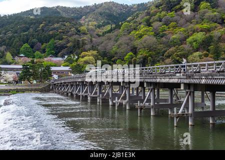 Kyoto, JAPON - 5 avril 2021 : Pont Togetsukyo, pont traversant la rivière Katsura qui traverse tranquillement la région de Saga Arashiyama, par temps nuageux. Banque D'Images