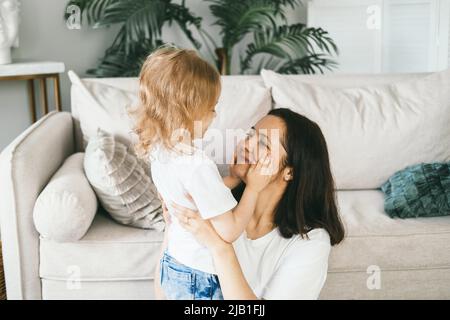 Une mère épouse doucement sa fille de quatre ans. Banque D'Images