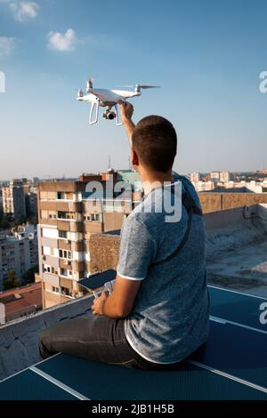 Jeune technicien homme volant UAV drone avec télécommande dans la ville Banque D'Images