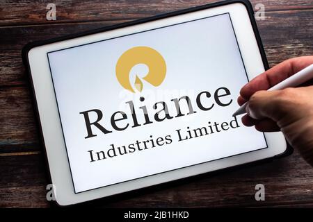 Kumamoto, JAPON - juillet 9 2021 : logo de la société indienne Conglomérat Reliance Industries Limited (RIL) sur tablette. Homme main tenant un stylo. Banque D'Images