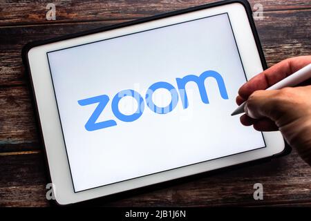 Kumamoto, JAPON - juillet 21 2021 : logo de l'application Zoom, vidéo et service de chat en ligne de la société américaine Zoom Video Communications, Inc., sur tablette. Homme tient le stylo Banque D'Images