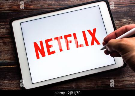 Kumamoto, JAPON - juillet 21 2021 : logo de Netflix, une société américaine de services de médias basée à Los Gatos, CA, sur tablette. Homme main tenant le stylet Banque D'Images