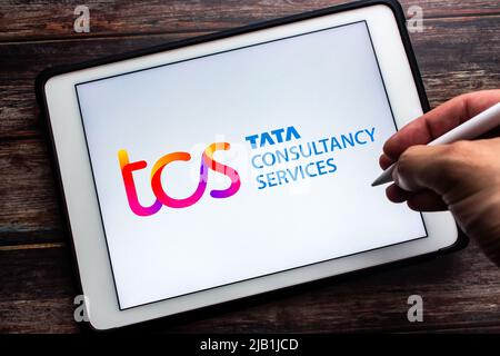 Kumamoto, JAPON - juillet 23 2021 : logo de Tata Consultancy Services (TCS), une société indienne DE CONSEIL ET D'INFORMATIQUE, sur tablette. Homme tenant le stylet Banque D'Images