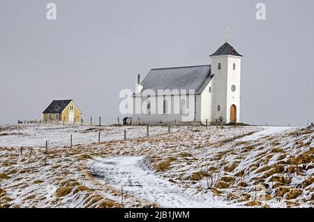 Flatey, Islande, 6 mai 2022 : l'église et la bibliothèque de l'île pendant une rare occasion avec neige et soleil Banque D'Images