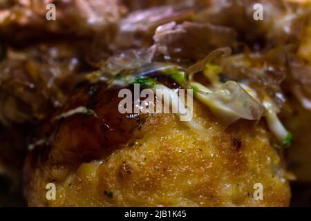 Gros plan Takoyaki (boulettes de pieuvre), encas japonais de rue à base de pâte, morceaux de pieuvre et autres ingrédients avec sauce takoyaki et mayonnaise Banque D'Images