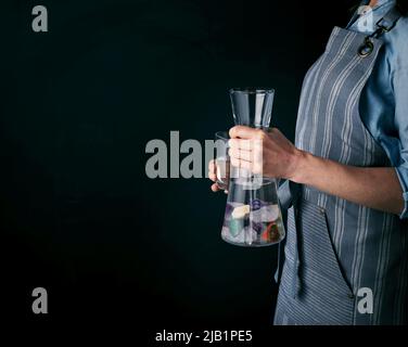 Jeune femme avec un verre d'eau et des pierres précieuses pour boire de l'eau saine avec un espace de copie sur fond noir. Banque D'Images