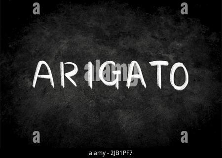 “Arigato” par écriture blanche craie sur tableau noir. La surface du tableau noir est poudreuse et rugueuse. Sayonara signifie Merci en japonais Banque D'Images