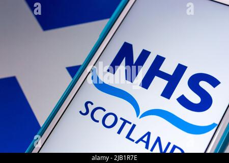 Kumamoto, JAPON - septembre 6 2021 : logo Closeup de NHS Scotland, le système de santé financé par l'État en Écosse, sur iPhone drapeau écossais. Banque D'Images