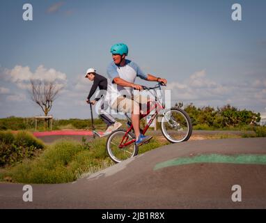 Merville, France, mai 2022. Homme avec un casque à vélo BMX dans le parc de skate. Journée ensoleillée, détente, style de vie sportif Banque D'Images