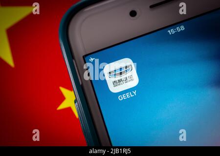 Kumamoto, JAPON - août 16 2021 : icône de la compagnie automobile chinoise Geely (marque Geely Auto) sur iPhone drapeau chinois dans l'humeur sombre Banque D'Images