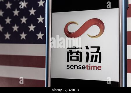 Kumamoto, JAPON - Déc 14 2021 : logo de SenseTime, société de logiciels d'intelligence artificielle de premier plan basée à Hong Kong, sur iPhone, drapeau américain d'humeur sombre Banque D'Images