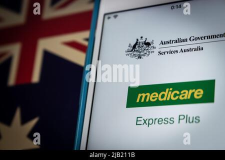 Application mobile Express plus Medicare sur iPhone, drapeau australien dans l'obscurité. C'est le service de gestion de l'assurance-maladie de Services Australia Banque D'Images