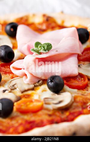 Pizza aux olives, champignons, jambon et origan frais. Banque D'Images