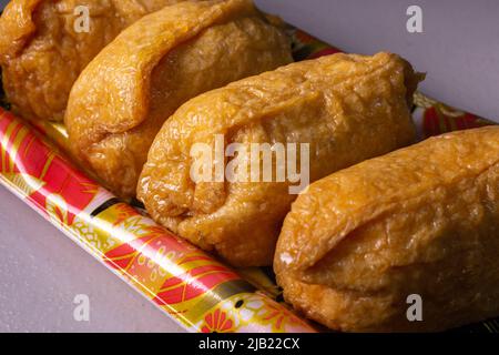 Gros plan à emporter Inarizushi (sushi Inari ou sushi de renard), un type de sushi fait avec une boule de riz à sushis assaisonné enveloppé d'abura-âge (un sachet de frit Banque D'Images