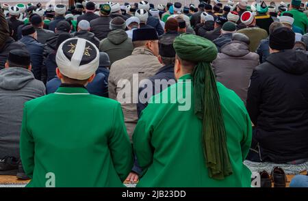 Des hommes musulmans priant. Une prière de masse du vendredi musulman. Vêtements musulmans traditionnels. Vue de l'arrière. Banque D'Images