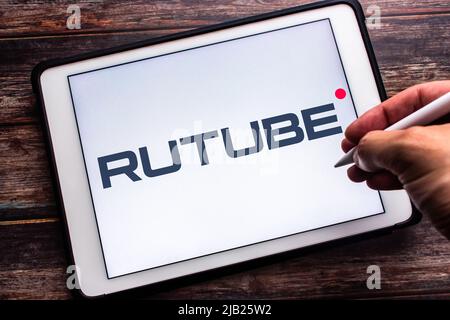 Kumamoto, JAPON - 12 mai 2022 : Un signe de Rutube, une plate-forme vidéo russe appartenant à Gazprom-Media, sur une tablette sur une table. Homme main tenant le stylet Banque D'Images