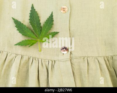 Gros plan d'une robe en fibre de chanvre biologique avec une feuille de chanvre. Banque D'Images