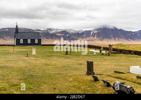 La minuscule église en bois Búðakirkja (Islande) date du 19th siècle dans une zone naturelle pittoresque avec un champ de lave. L'église a été préservée malgré le décret du clergé de Steinunn Sveinsdottir, qui a trouvé son dernier lieu de repos dans le cimetière Banque D'Images