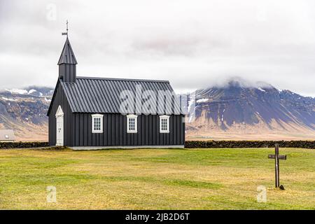 La minuscule église en bois Búðakirkja (Islande) date du 19th siècle dans une zone naturelle pittoresque avec un champ de lave. L'église a été préservée malgré le décret du clergé de Steinunn Sveinsdottir, qui a trouvé son dernier lieu de repos dans le cimetière Banque D'Images