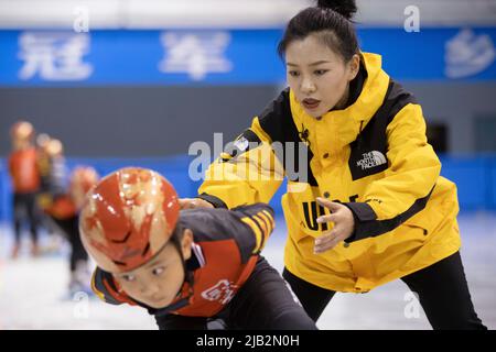 (220602) -- QITAIHE, 2 juin 2022 (Xinhua) -- Xu Zichun, entraîneur de l'école d'athlétisme amateur de jeunesse Boli, guide un jeune athlète au centre sportif de Qitaihe, dans la ville de Qitaihe, dans la province de Heilongjiang, au nord-est de la Chine, à 30 mai 2022. La ville de Qitaihe, dans la province de Heilongjiang, célèbre pour ses talents de patinage de vitesse sur piste courte, a formé 10 champions du monde dont Yang Yang, Wang Meng et Fan Kexin. Des générations de coachs de la ville se sont efforcés de découvrir et de former de jeunes talents pour le patinage de vitesse sur piste courte. (Xinhua/Zhang Tao) Banque D'Images