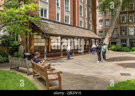 Les gens regardent le Watts Memorial to Heroic Self-sacrifice dans Postman's Park , un jardin public ombragé dans la ville de Londres, Londres EC1 Banque D'Images